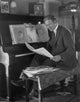 Tom Santchi reading at his piano photo print showcasing creativity and passion