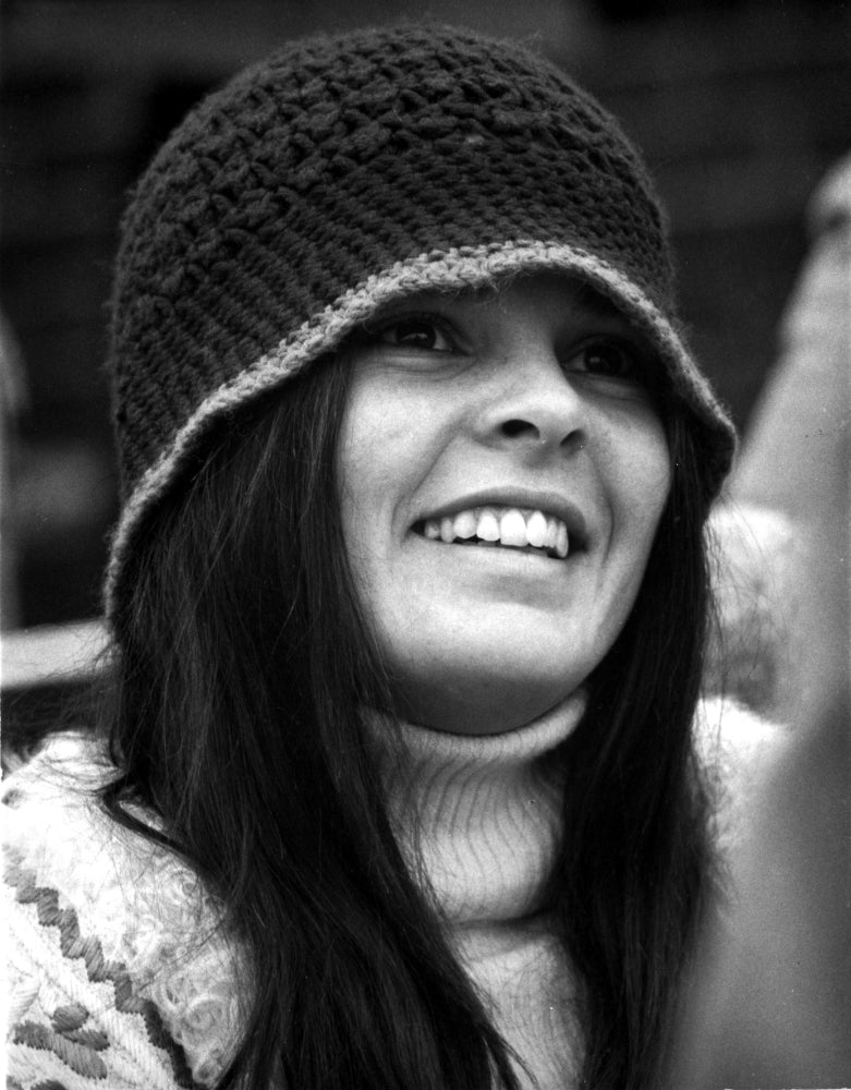 Ali MacGraw smiling while wearing a bonnet, vintage photo print.