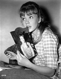 Hayley Mills photo print wearing a printed polo holding a camera.