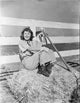 Barbara Stanwyck classic portrait photo print sitting in haystack.