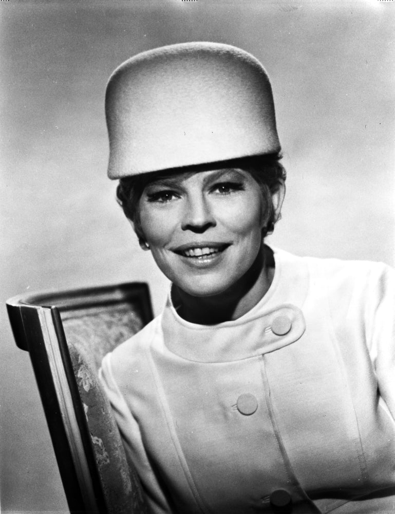 Classic portrait photo print of Ann Jackson sitting in a chair wearing a white coat.