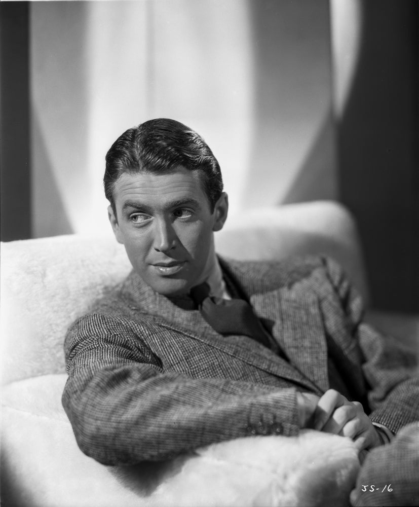 James Stewart photo print - sitting on couch in grey tweed sport coat.
