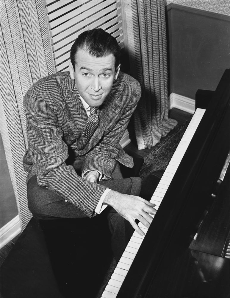 James Stewart seated at a piano in a grey sport coat photo print