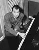 James Stewart seated at a piano in a grey sport coat photo print