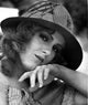 Close-up portrait of Bernadette Peters in a round wool hat and white blouse.