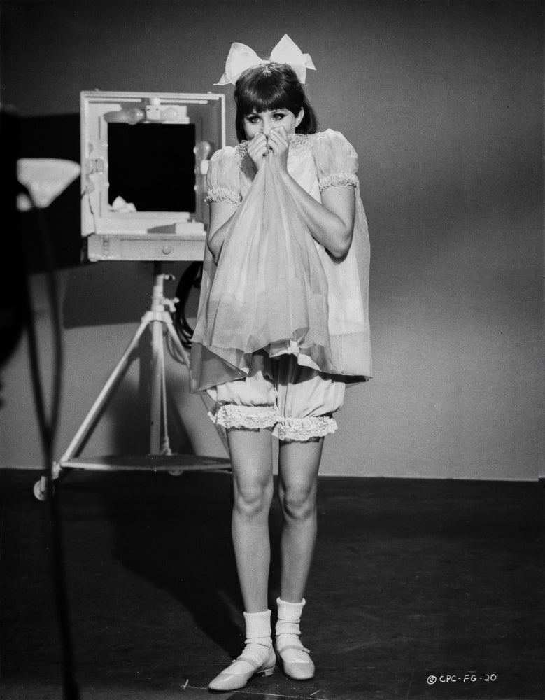 Barbra Streisand posed in a white dress with ribbon photo print.
