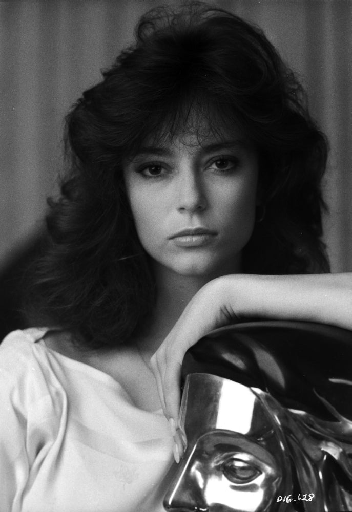 Rachel Ward reclining on a golden statue in a white dress photo print.