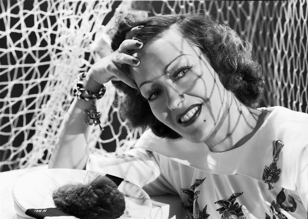 Classic portrait photo print of Gloria Swanson smiling with red lipstick and curly hair.