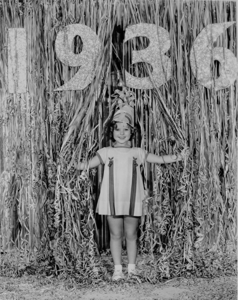 Shirley Temple wearing a white tent dress in a classic portrait photo print.