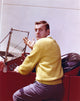 Jerry Van Dyke photo print in yellow knitted coat and grey linen pants.