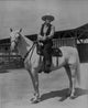 John Wayne on white horse photo print showcasing classic cinema.