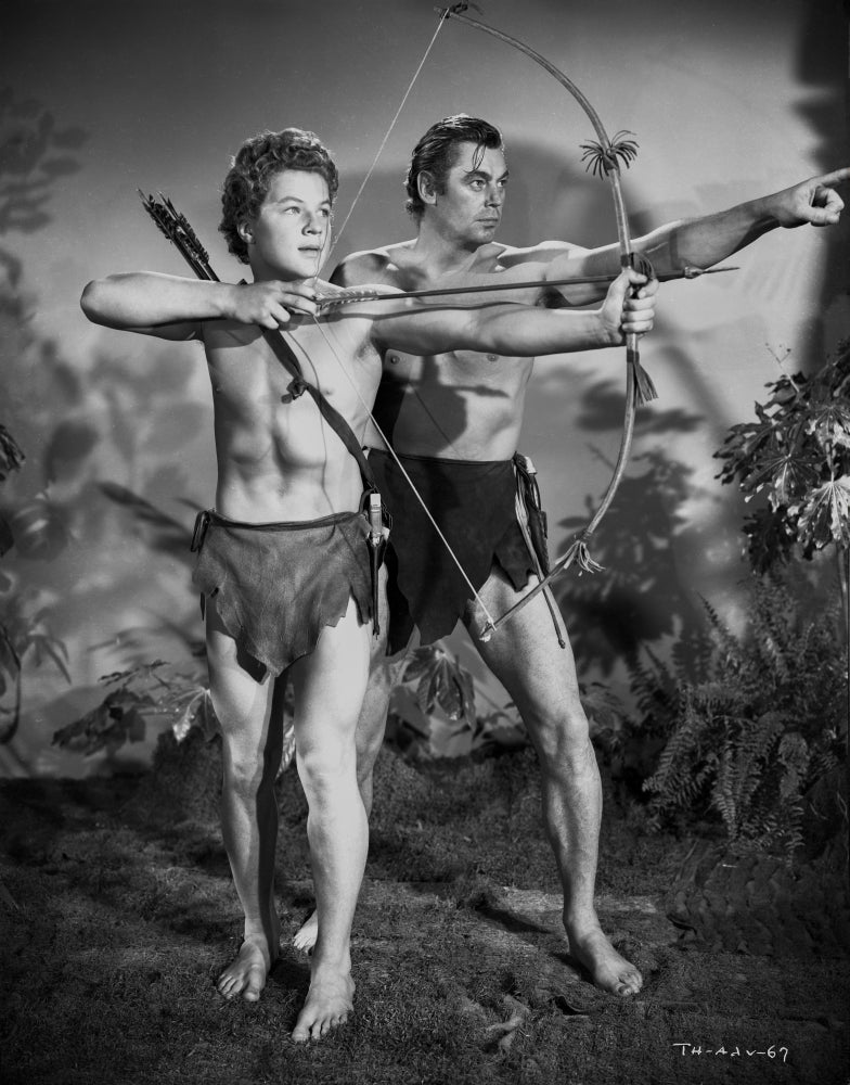Johnny Weissmuller leading a young man in a classic movie scene photo print.