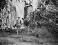 Johnny Weissmuller standing near waterfalls with child in movie scene photo print