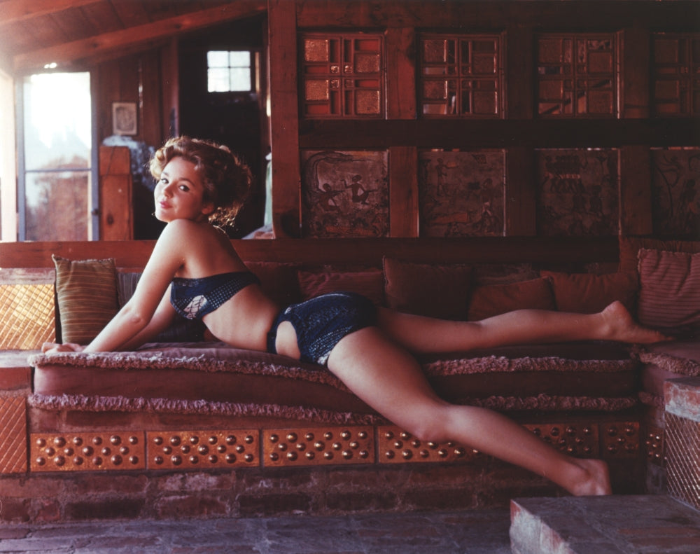 Tuesday Weld lying on a brown couch photo print