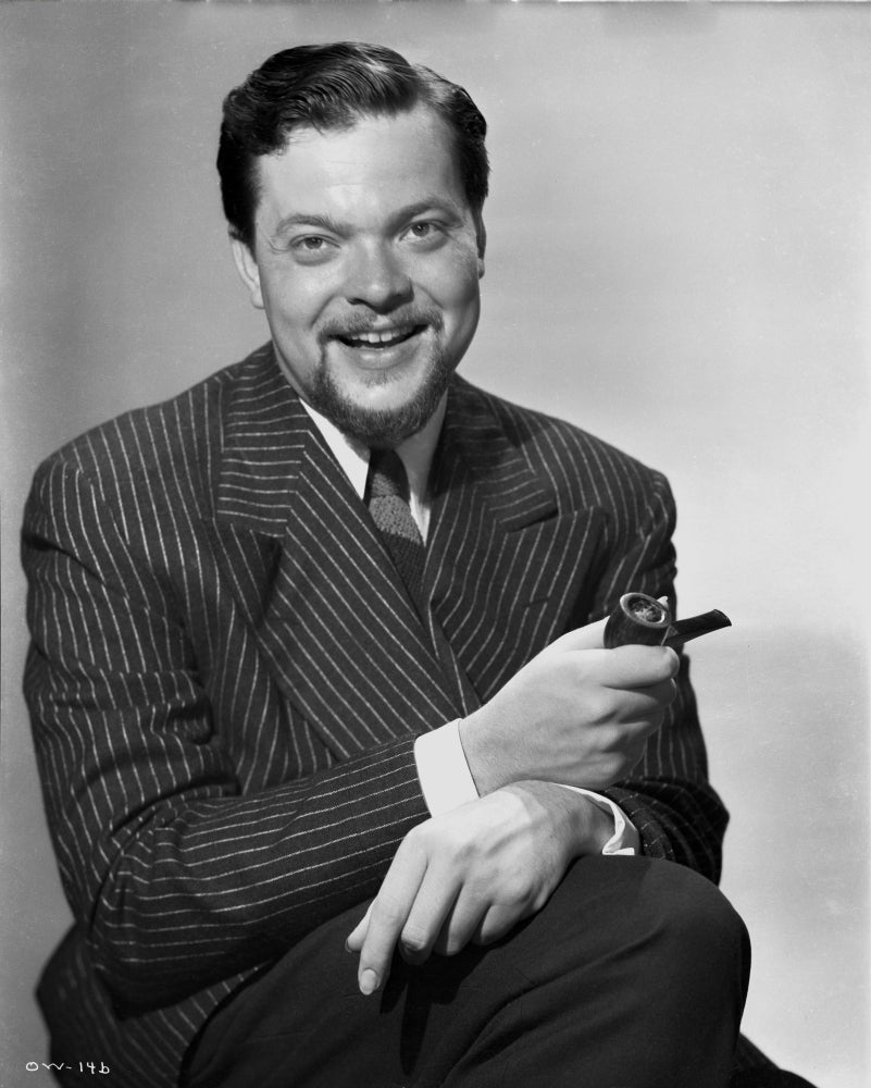Orson Welles smiling in black and white photo print.