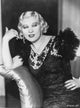 Mae West photo print in black dress with hand on hips.