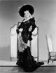 Mae West posed in black glossy dress and hat photo print.