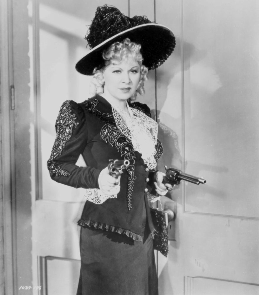 Mae West holding two pistols in a black and white dress photo print.