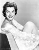 Esther Williams seated on embroidered flower mesh, classic photo print.