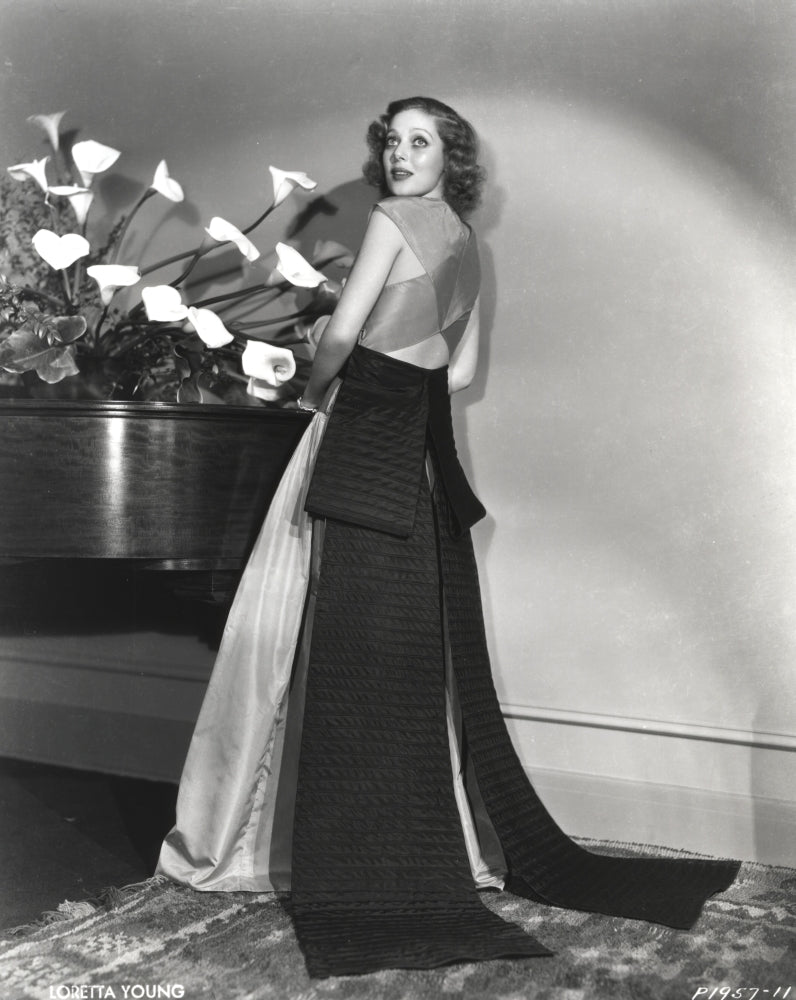 Loretta Young in elegant long gown with black ribbon photo print.