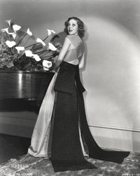 Loretta Young in elegant long gown with black ribbon photo print.