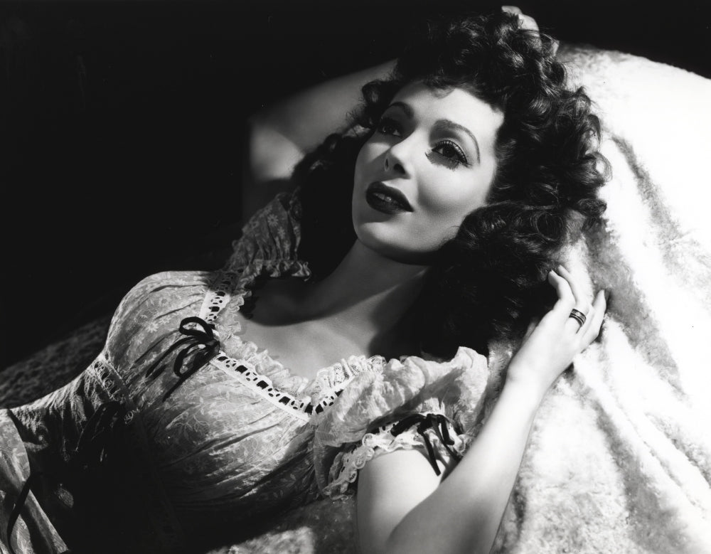 Loretta Young lying in bed photo print with curly hair.