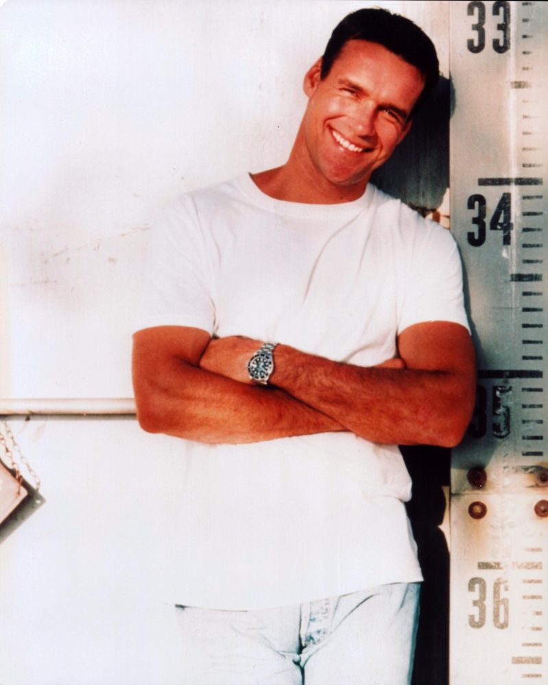 David James Elliott leaning against measuring wall photo print in all white.