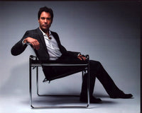 Eric McCormack photo print posed on chair in gray suit