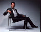 Eric McCormack photo print posed on chair in gray suit