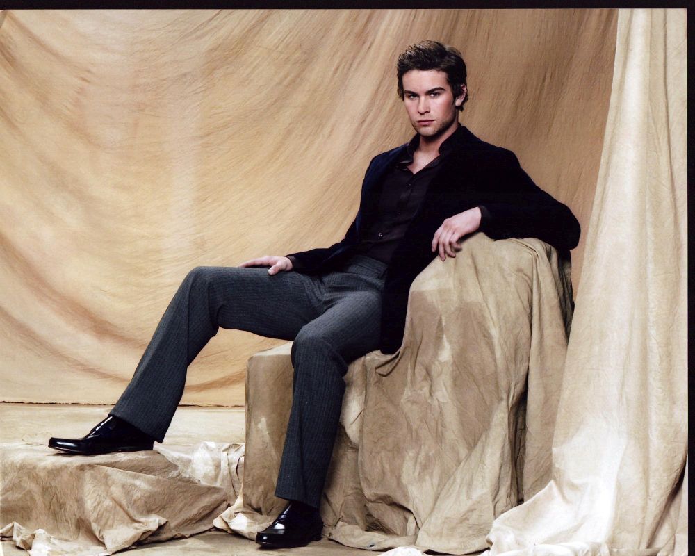 Chace Crawford stylish photo print in gray pants and black blazer.
