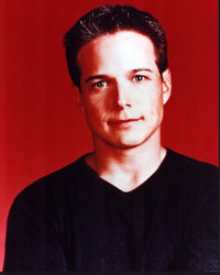 Scott Wolf photo print in black sweater with red background.