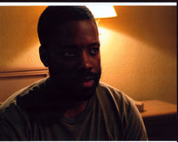 Kadeem Hardison photo print on hotel bed in gray shirt