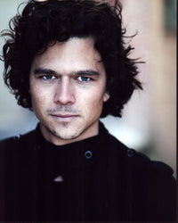 Photo print of Luke Arnold in a black top, showcasing style and charisma.
