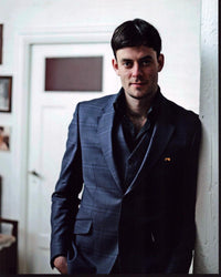 GíSli Ärn GarðArsson leaning on a wall in a green plaid suit photo print.