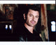Diego Serrano leaning on a rusted wall in a leather jacket photo print.