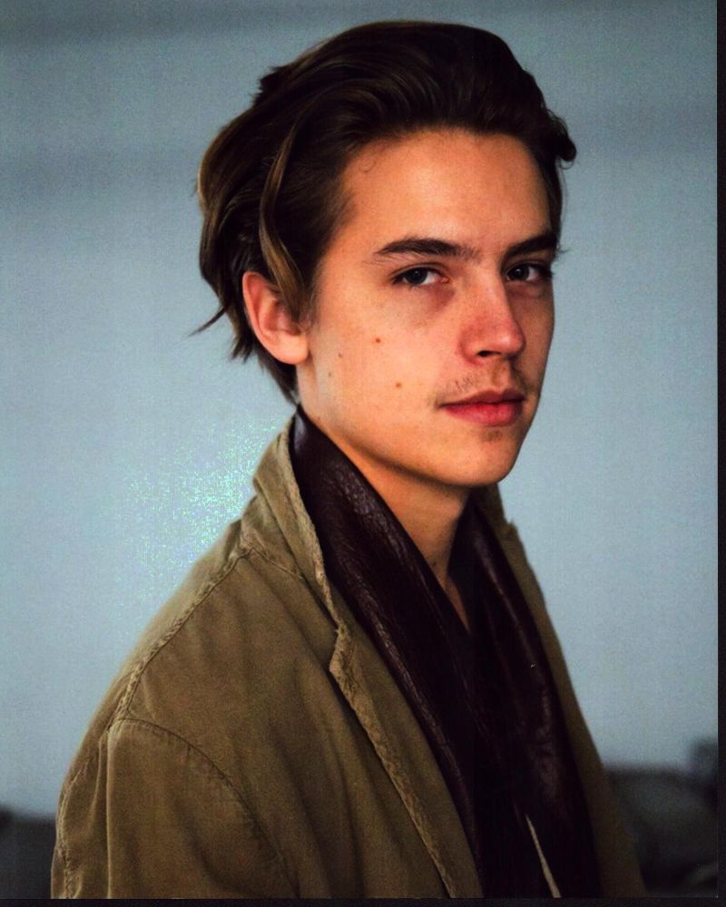 Cole Sprouse photo print in brown jacket with leather scarf.