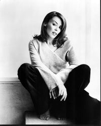 Kylie Minogue black and white photo print sitting in jeans and sweater.