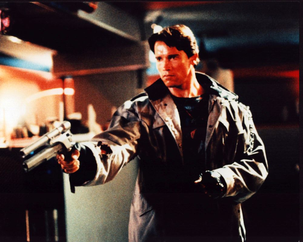 Arnold Schwarzenegger The Terminator photo print capturing the iconic character in a trench coat with a gun.