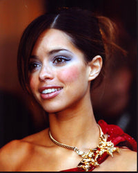 Tina Barrett photo print in one shoulder red top and gold necklace.