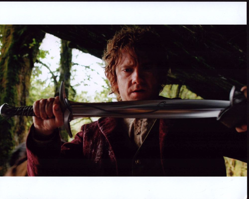 Martin Freeman as Bilbo Baggins holding sword in sheath from The Hobbit: An Unexpected Journey photo print.