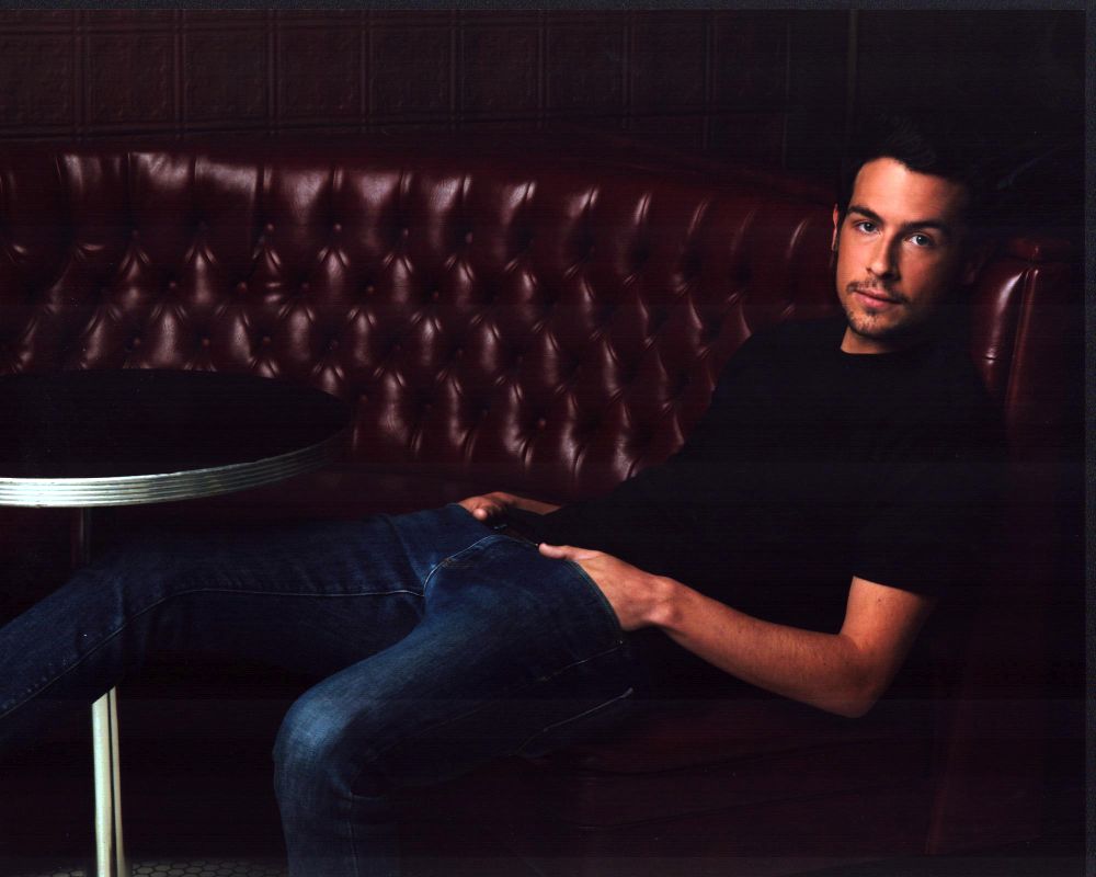 John Boyd sitting in a red leather booth photo print.