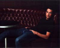 John Boyd sitting in a red leather booth photo print.