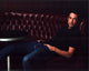 John Boyd sitting in a red leather booth photo print.