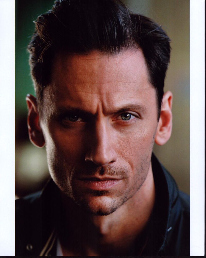 Derek Wilson headshot photo print in black jacket.