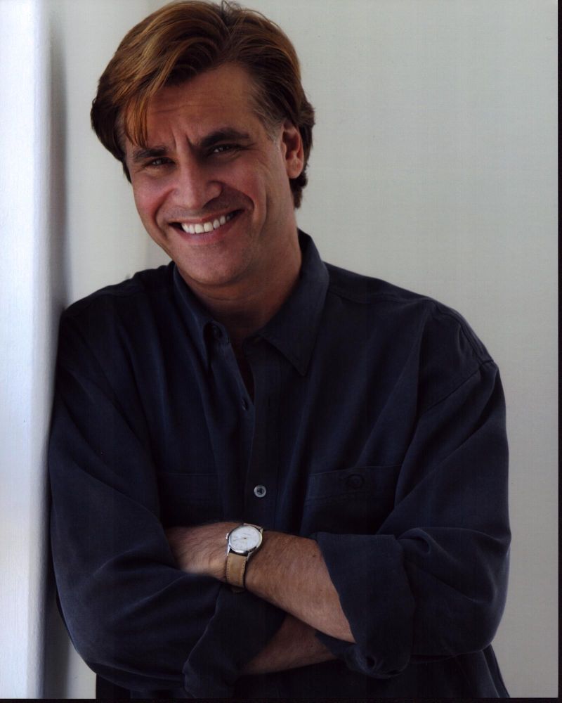Aaron Sorkin smiling leaning against a wall photo print