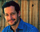 Jeremy Glazer headshot photo print in denim shirt against wood background