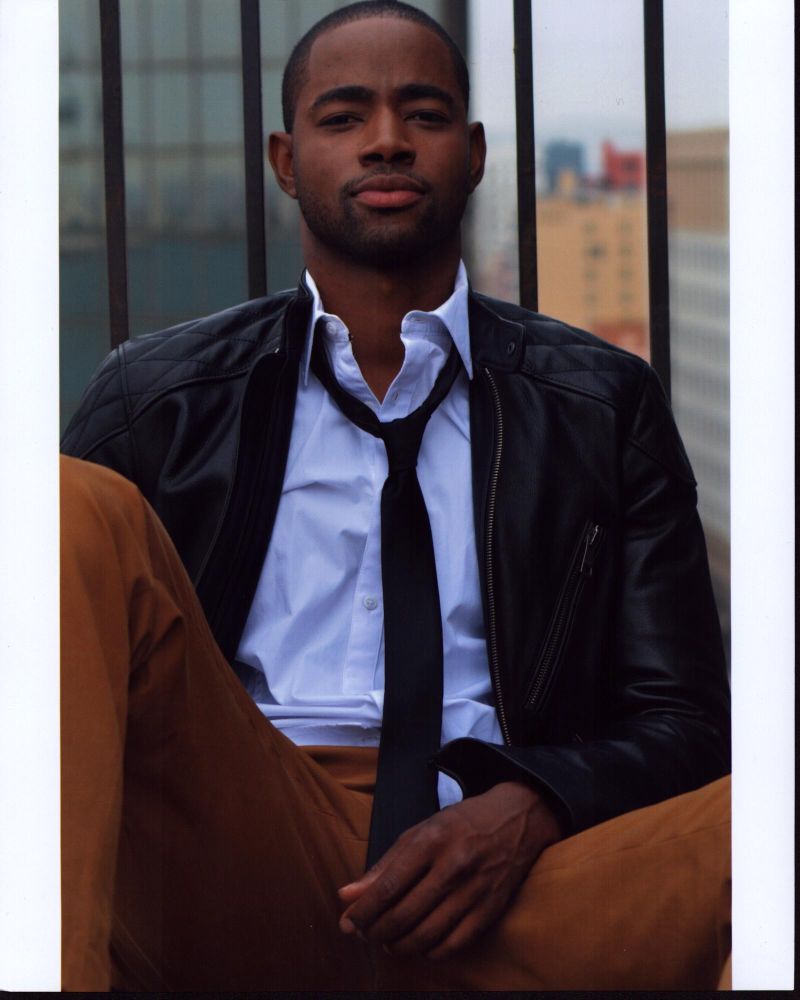 Jay Ellis photo print in leather jacket and tie against railing