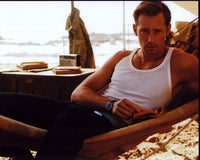 Photo print of Alexander Skarsgård reading in a hammock.