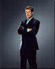 Dylan Walsh in a navy suit photo print, arms crossed, elegant portrait.