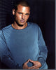 Justin Chambers leaning against a wall in a gray sweater photo print